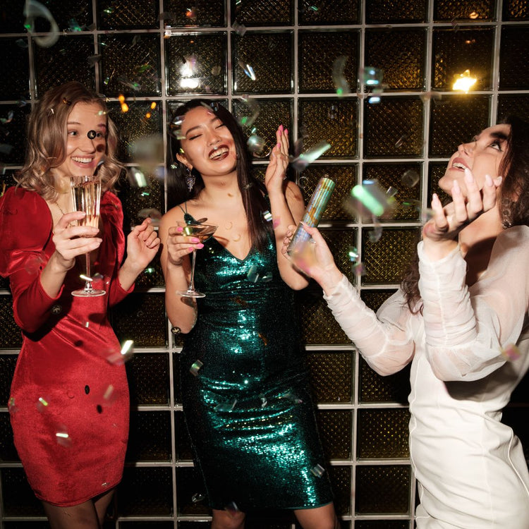3 amigas en una discoteca, tomando champán, disfrutando del momento en una fiesta en la que están muy a gusto.