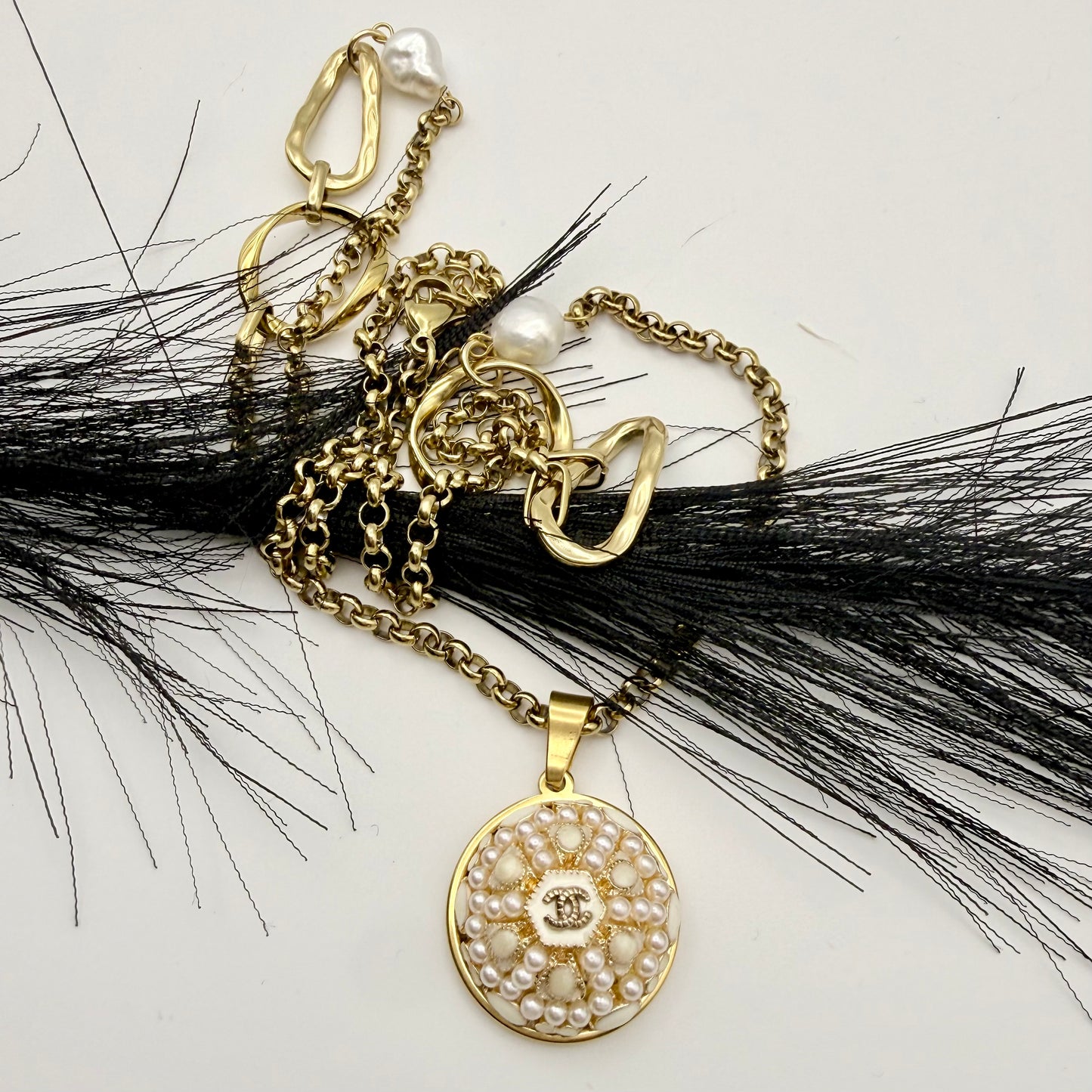 Joya artesanal sostenible con botón CHANEL reciclado, transformado en un collar sautoir muy elegante.