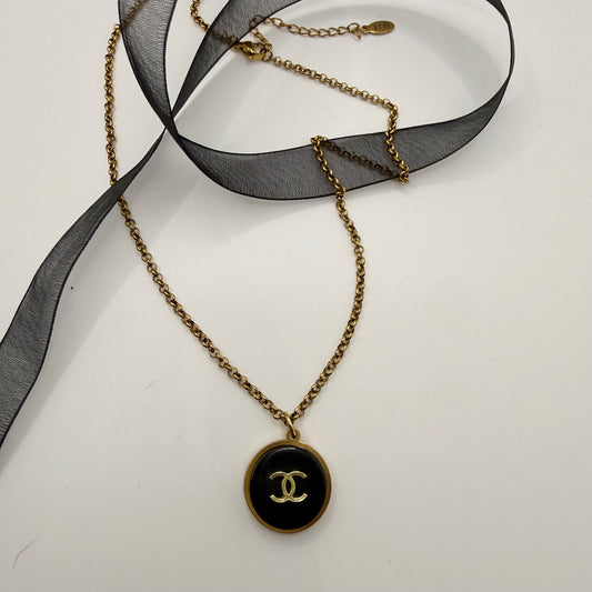 Collar artesanal EOS UPCYCLING hecho a mano con botón de marca de lujo recuperado.