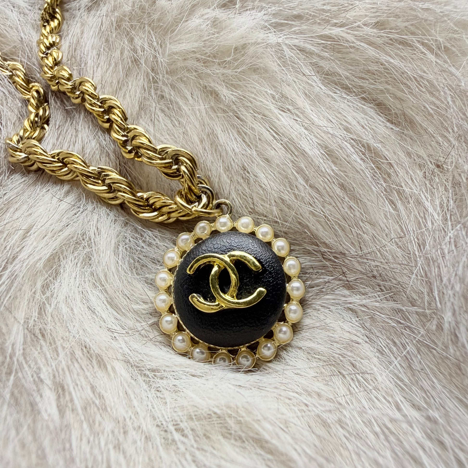 Detalle del botón recuperado de marca de lujo en collar artesanal DEMETRA creado a mano por EOS UPCYCLING