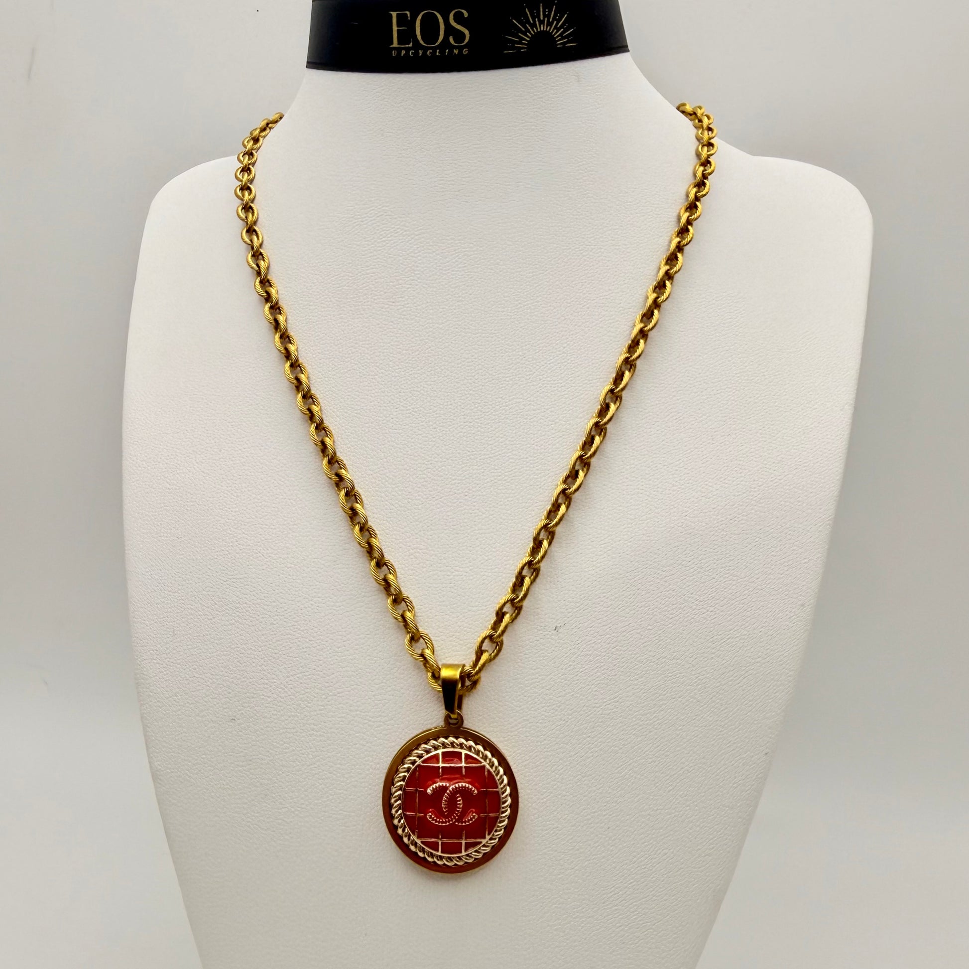 Joya artesanal sostenible con botón CHANEL reciclado.
