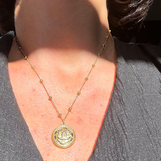 Collar artesanal EOS UPCYCLING  hecho a mano con botón de marca de lujo recuperado.
