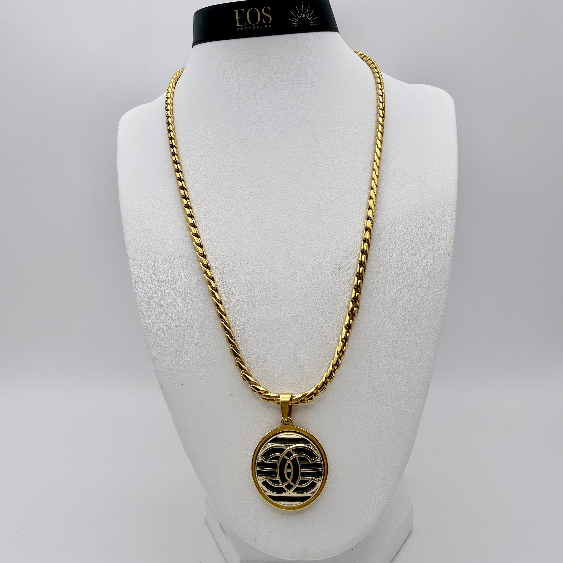 Joya artesanal sostenible con botón CHANEL reciclado.
