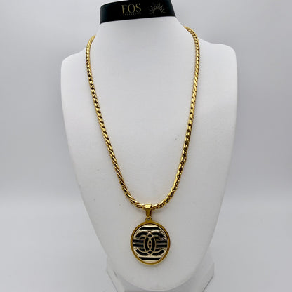 Joya artesanal sostenible con botón CHANEL reciclado.
