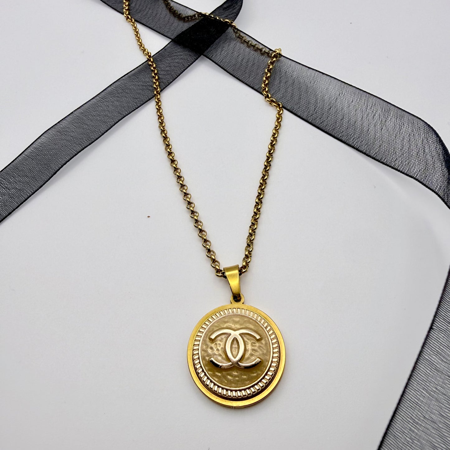 Joya artesanal sostenible con botón CHANEL reciclado, hecho a mano por EOS UPCYCLING. Una pieza elegante y original