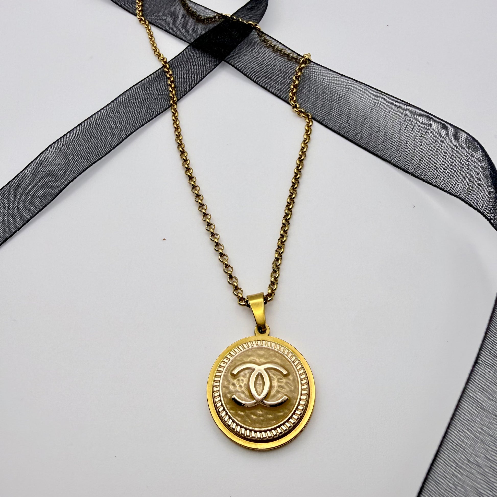 Joya artesanal sostenible con botón CHANEL reciclado, hecho a mano por EOS UPCYCLING. Una pieza elegante y original