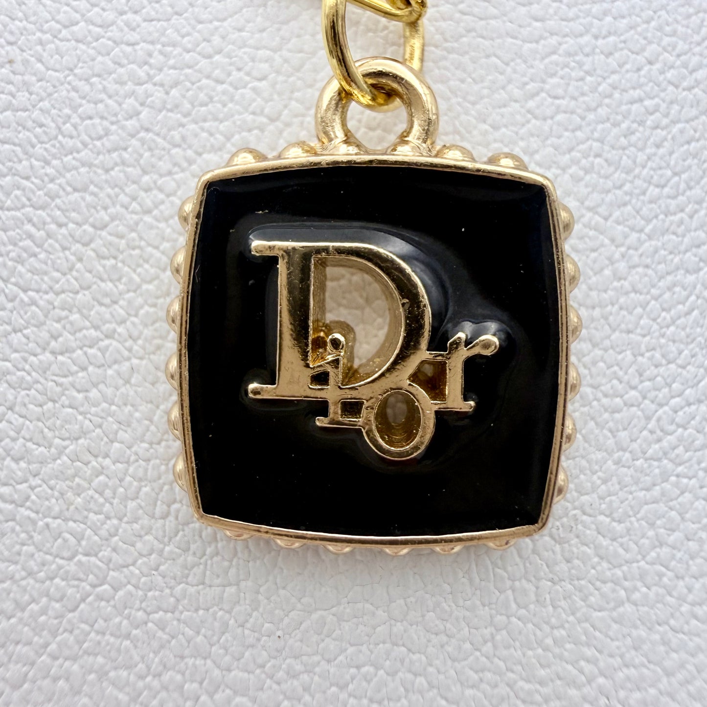 Joya artesanal sostenible creado a partir de un botón DIOR reciclado.
