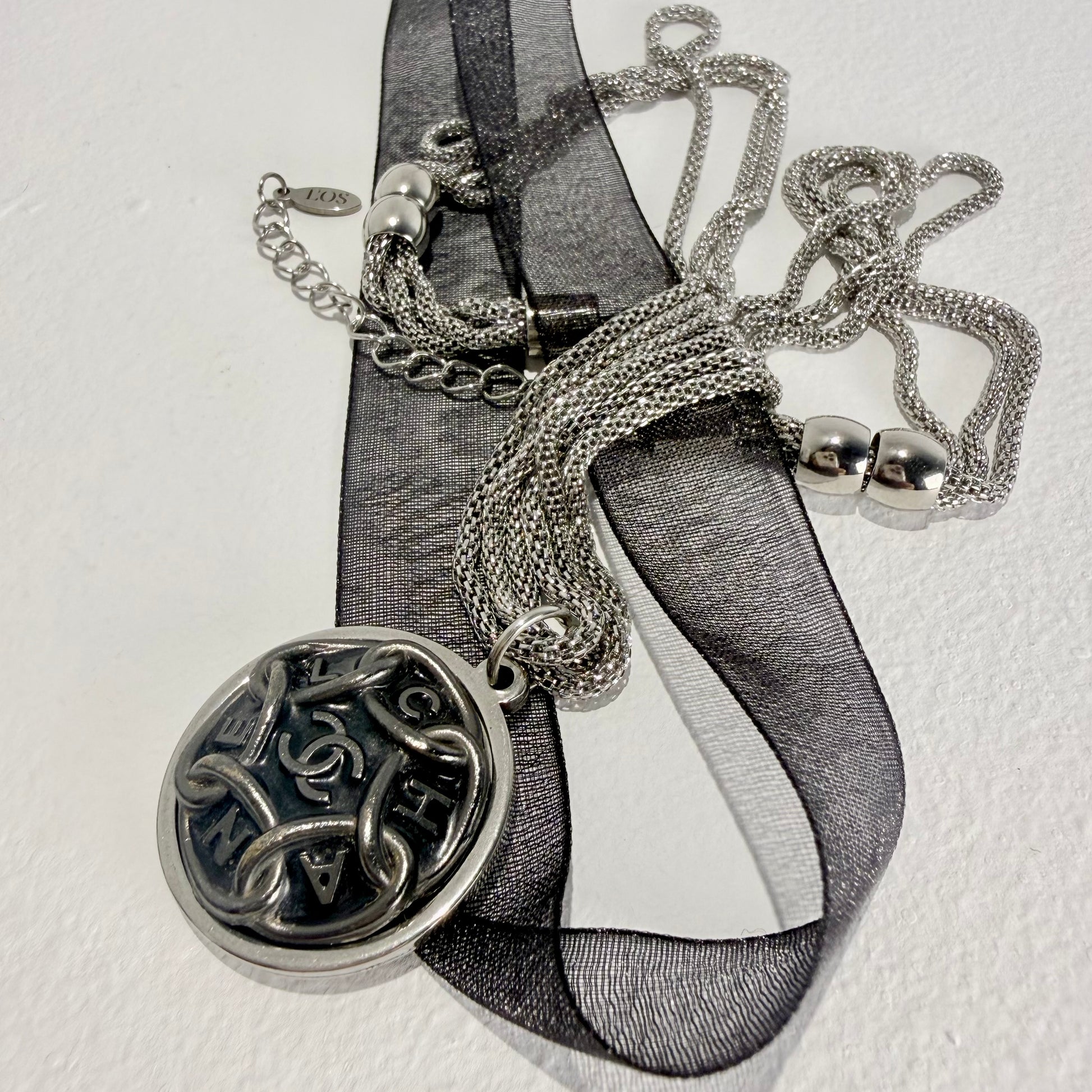 Tres cadenas finas de malla redondeada entrelazadas en collar artesanal LIMOS. 
