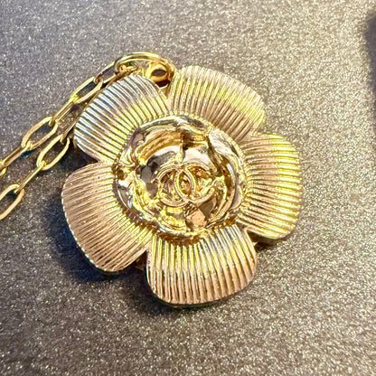 Joya artesanal sostenible con botón CHANEL reciclado en formato de flor.  una segunda vida a piezas con historia a través de un enfoque de upcycling consciente.
