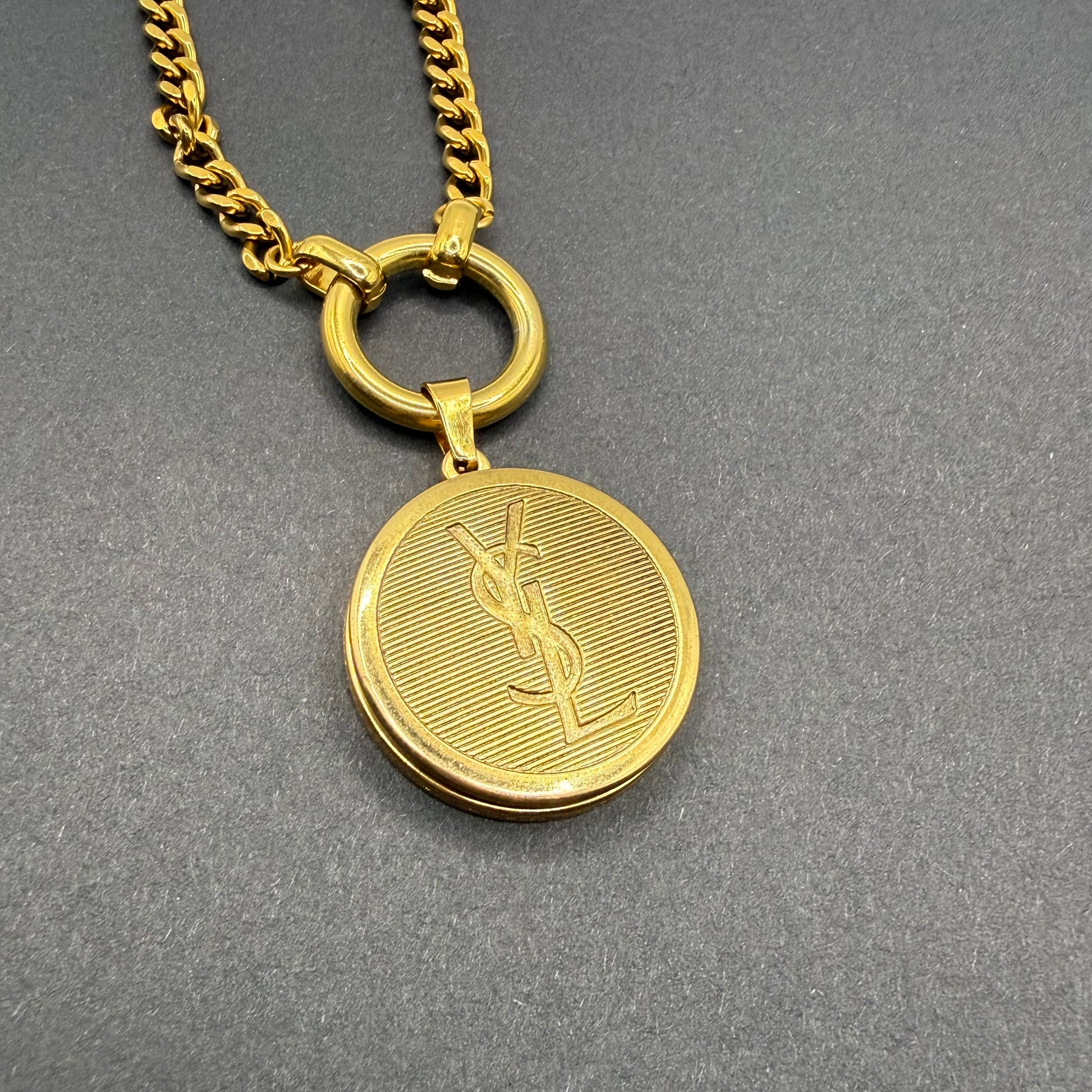 Detalle del botón YVES SAINT LAURENT en collar artesanal SYROS