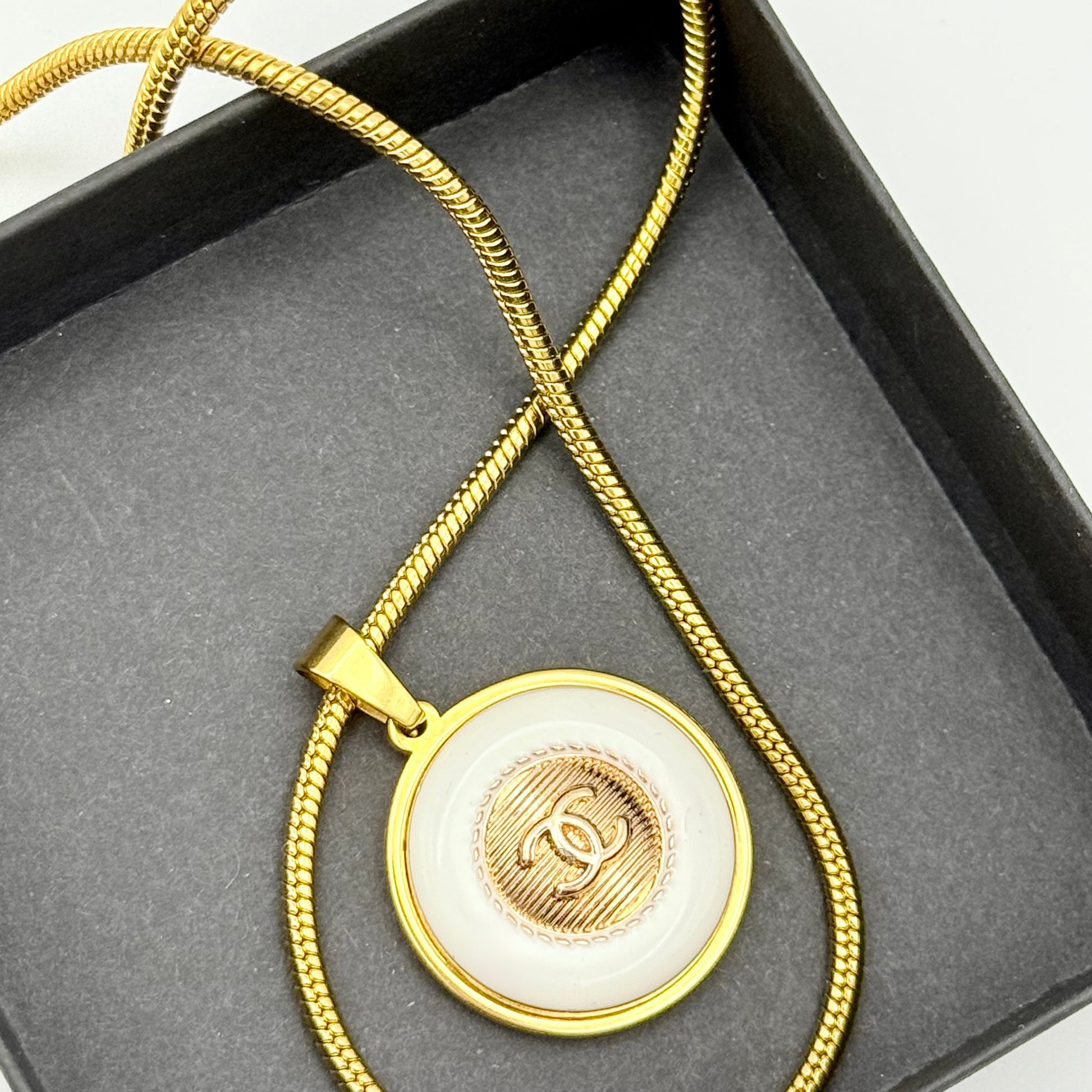 Detalle del botón CHANEL en collar artesanal PASIFAE